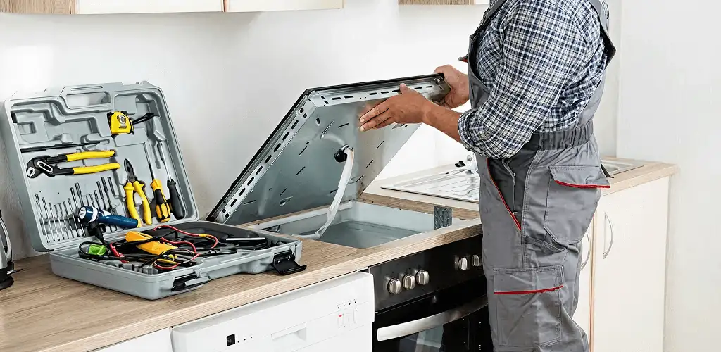 Handyman repairing a cooktop and checking wiring connections in Rockford, IL