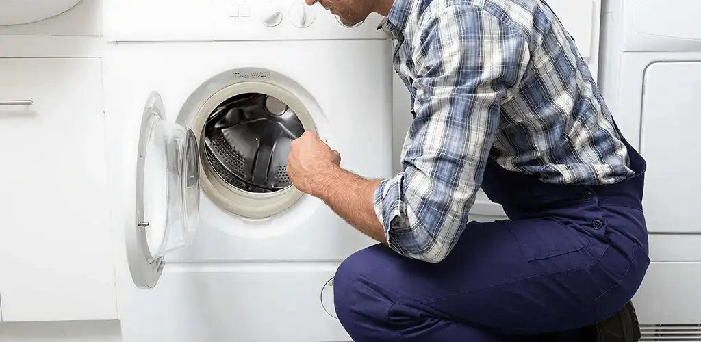 Handyman inspecting a dryer drum and internal parts for repair in Rockford, IL