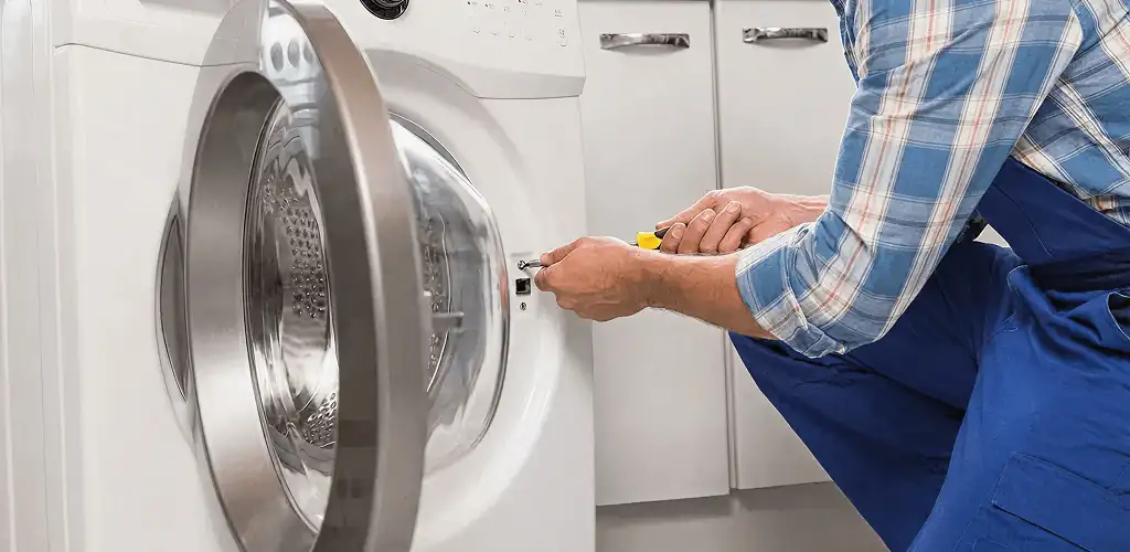 Handyman repairing a clothes dryer and checking electrical connections in Rockford, IL