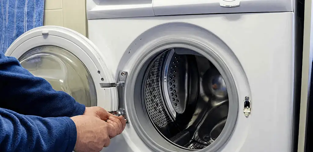 Washing machine repair handyman checking a front-load washer door and latch in Rockford, IL