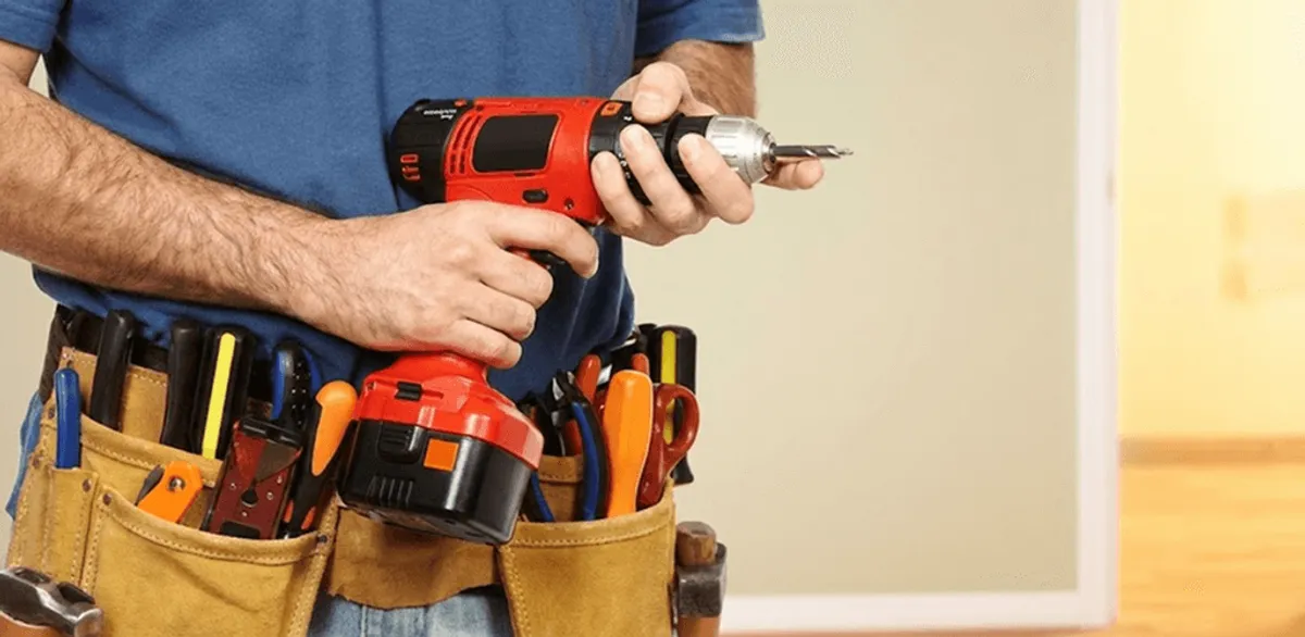 Handyman holding a power drill for home repairs and installations in Rockford, IL