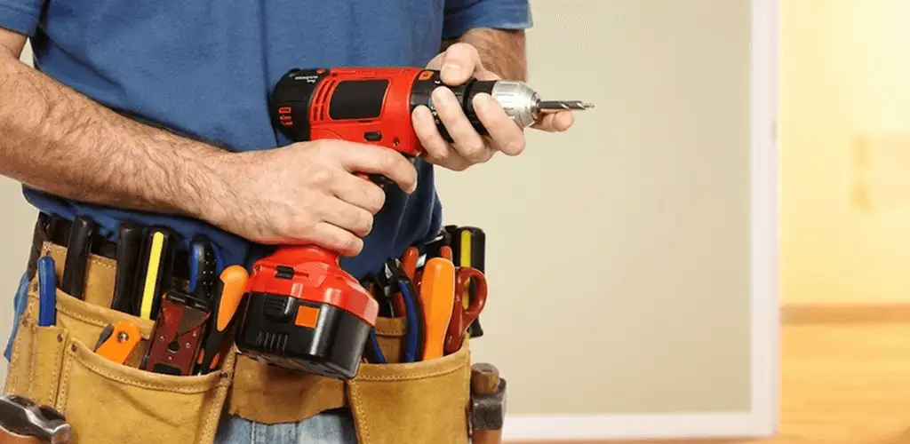 Handyman holding a power drill for home repairs and installations in Rockford, IL