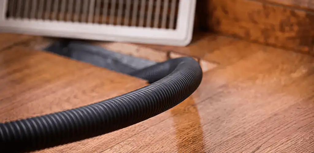 Air duct cleaning hose inserted into a floor vent for ductwork cleaning in Rockford, IL